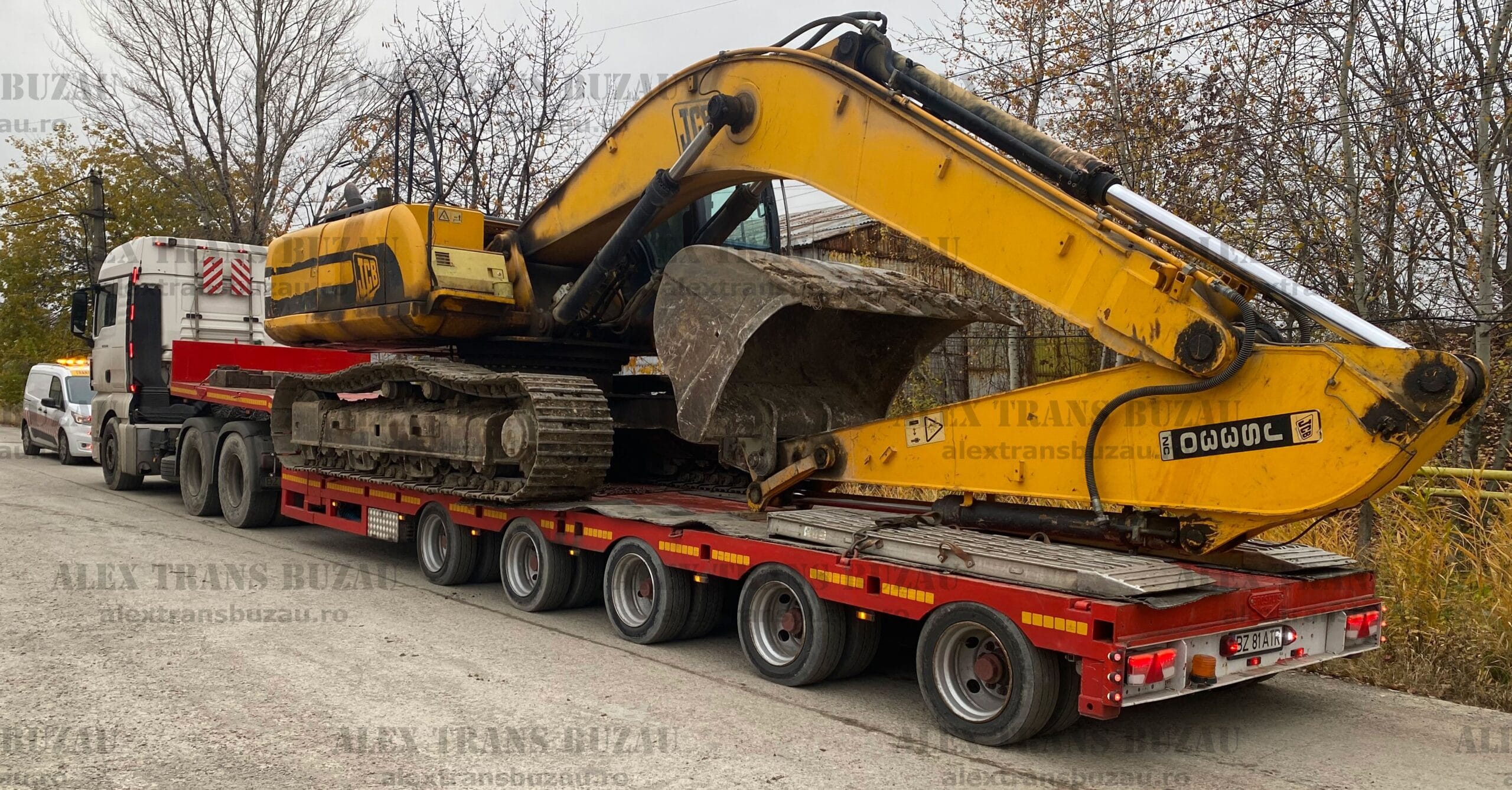 Camion Volvo transport utilaje grele buldozer pe rampă hidraulică în șantier